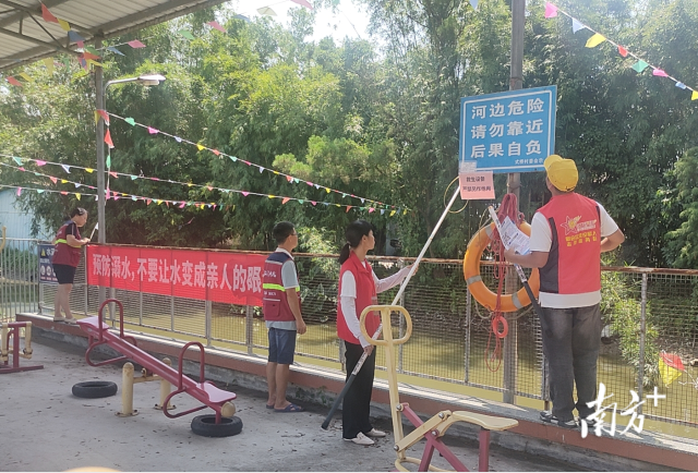 网格员们正在检查河岸旁提醒防溺水的告示和救护装置。 受访者供图 图片